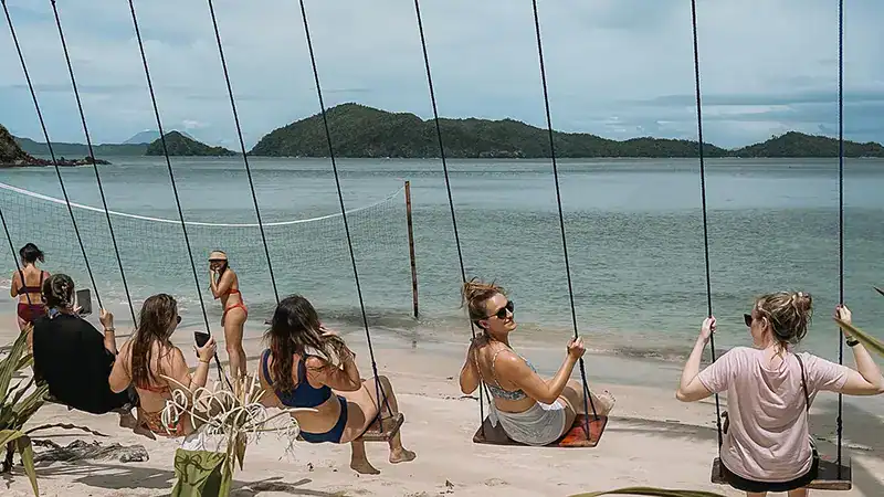 swing in palawan A group of travelllers experiencing sea-view swing in Palawan