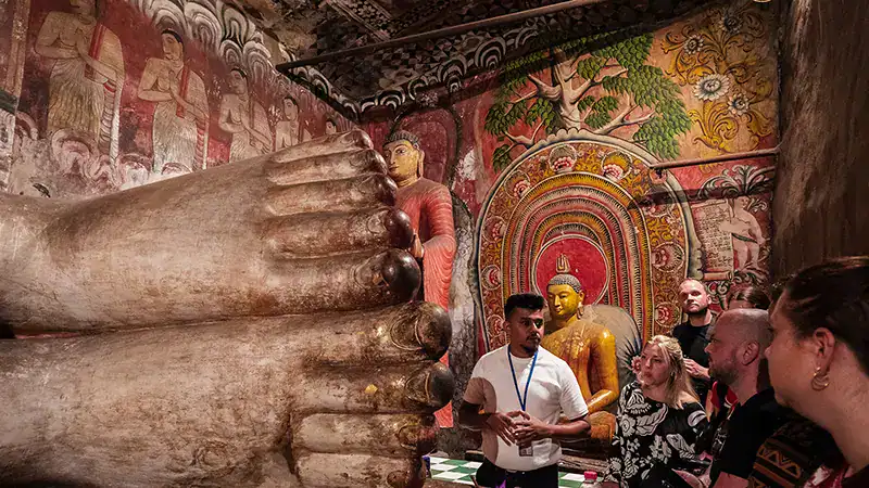 Travellers while visiting Dambulla Cave with the big Feet Statue