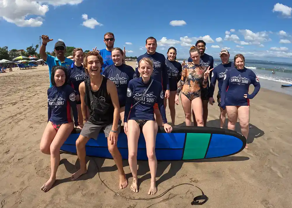 Guests on small group adventure travel tour in Bali doing a first-time surf lesson experience