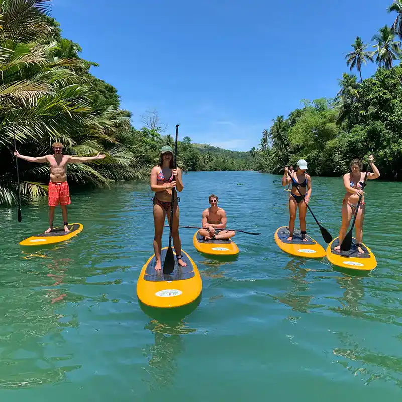 Small group of travellers enjoying paddleboarding in paradise on Philippines tour